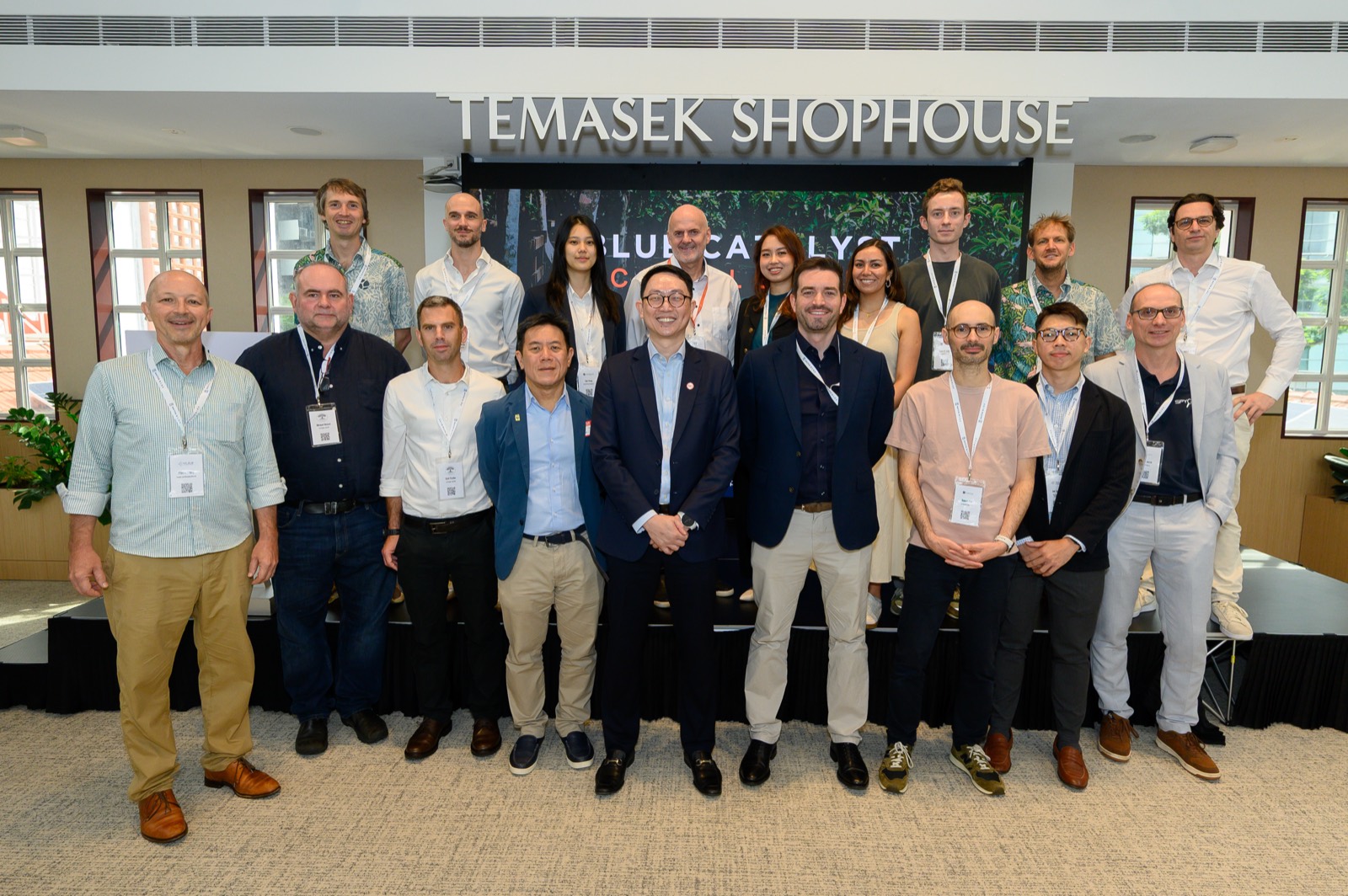 The Blue Catalyst cohort — ventures and organisers — gathered on stage beneath the Temasek Shophouse sign in Singapore.